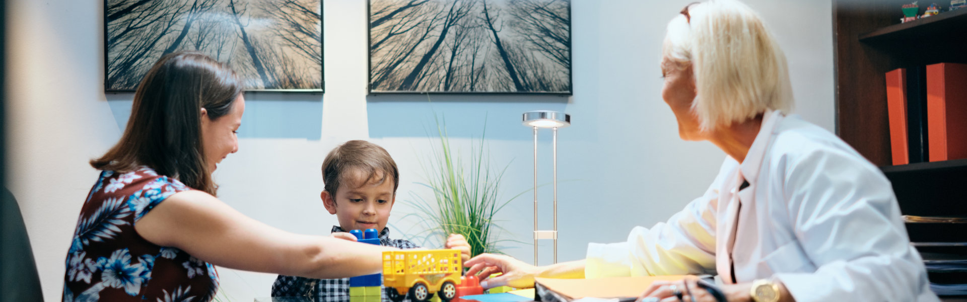 pediatrician with mom and ill young boy in medical clinic