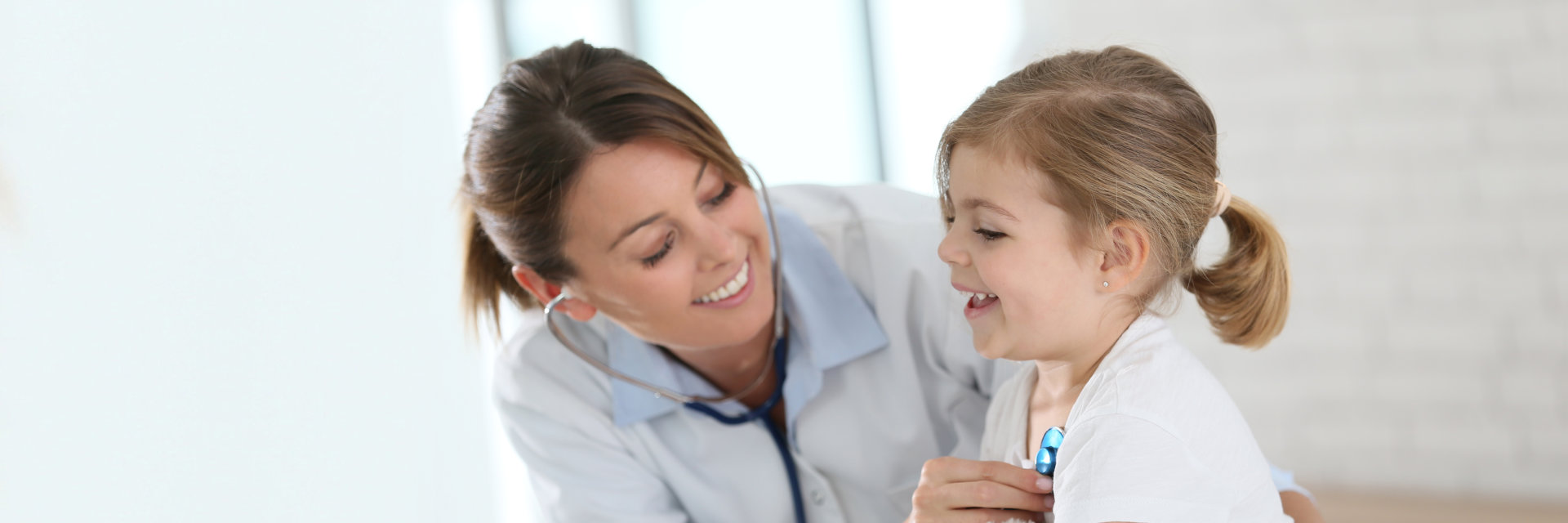 Doctor examining little girl with stethoscope